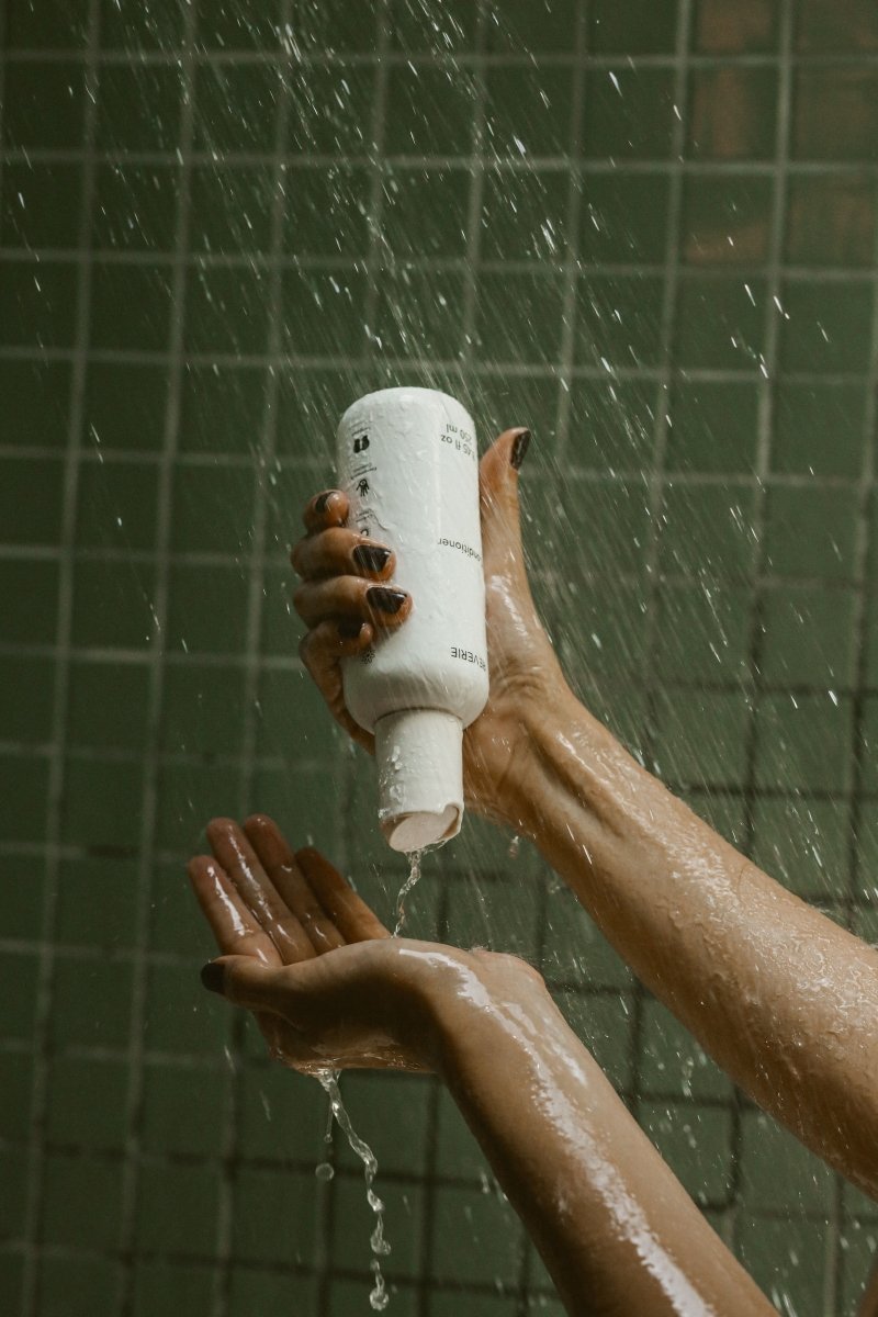 How to apply hair conditioner for soft shiny hair - woman using natural conditioner on wet hair after shampooing Bota