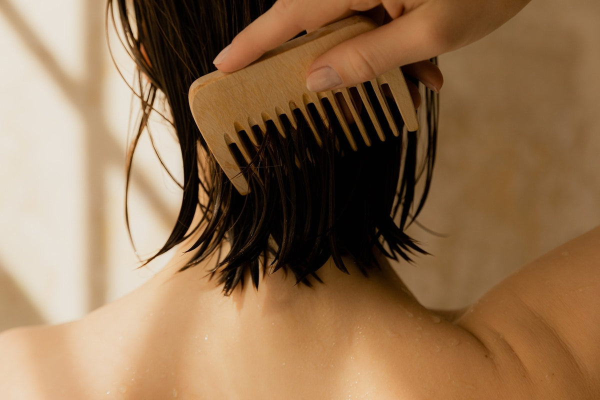 A wide-tooth comb drawn through damp hair
