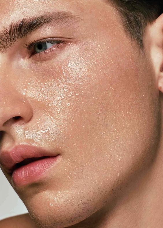 Close-up of a man's face with water droplets on his skin