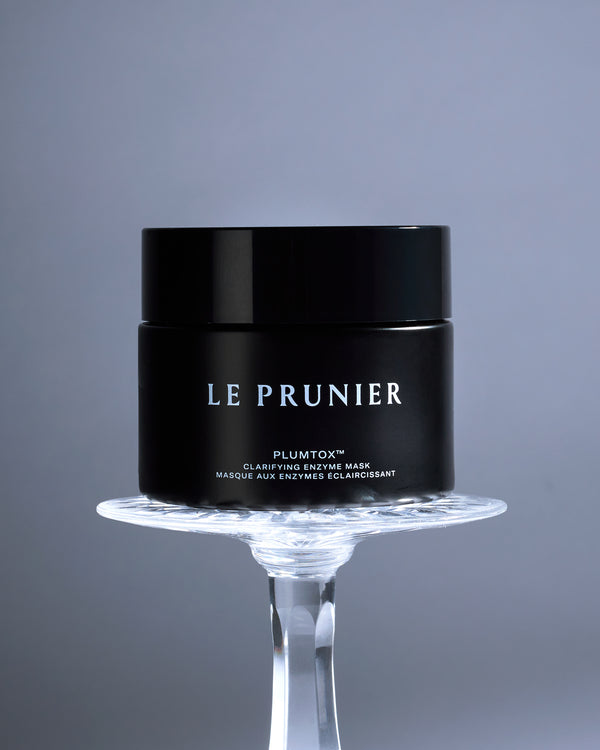 Le Prunier Plumtox Clarifying Enzyme Mask jar raised on a glass stand against a grey backdrop | Botā natural skincare.