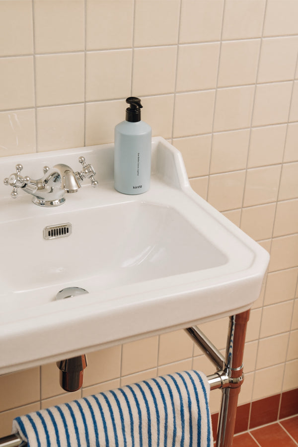 Kinfill hand wash in the refillable Ever Bottle Pump on a bathroom sink — Santal & Cedar refill | Botā