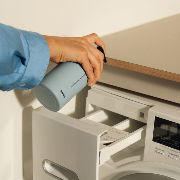 Pouring Kinfill laundry detergent from the Ever Bottle into a washing machine drawer | Botā